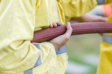 Firefighter holding rubber tubeの写真素材