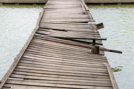 Deformed and dilapidated wooden bridge - Damage old wooden bridgeの写真素材