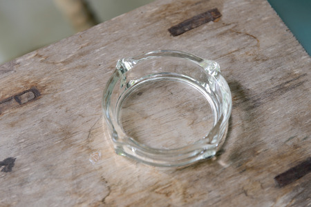 Empty glass ashtray on wooden tableの写真素材