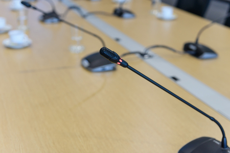 Selective focus conference microphones on the table in empty meeting room