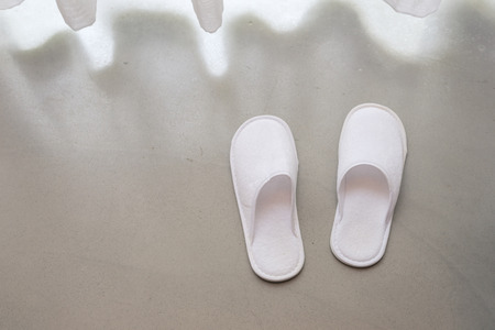 White slippers by white sheer curtains and soft sunlight, vacation conceptの写真素材
