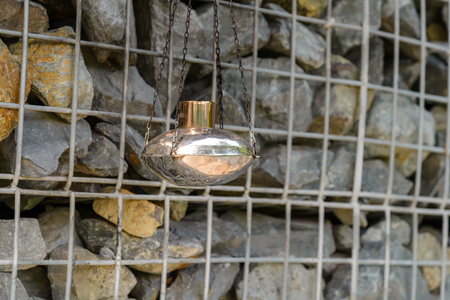 kerosene lamp hanging with gabion rock wall on backgroundの写真素材