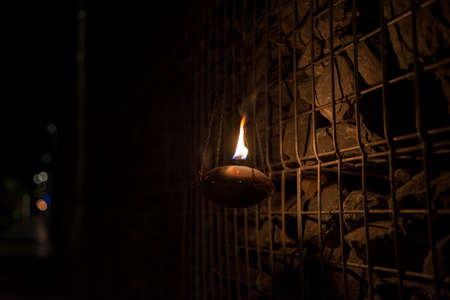 kerosene lamp hanging with gabion rock wall on backgroundの写真素材