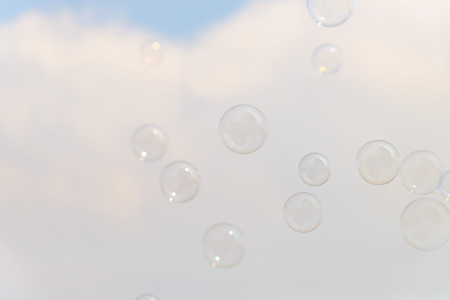 Soap bubbles in the air with cloud and blue sky on background, Outdoor activity funny and partyの写真素材