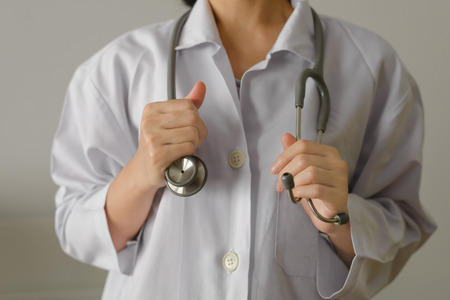 Close up of female doctor standing and holding stethoscope for check patient with copy space
