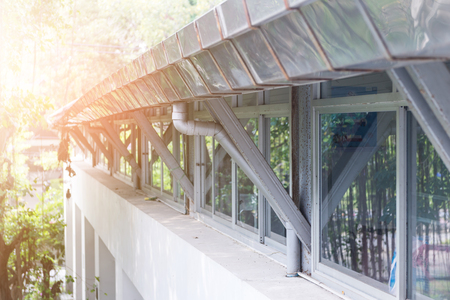 rain gutter with down pipe on rooftop of building preparing before rainyの写真素材