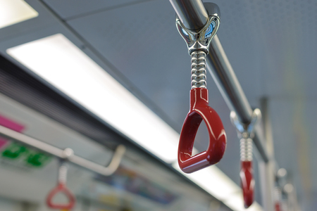 Red handle for standing passengers inside train or bus whit copy spaceの写真素材