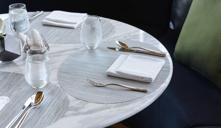 Table setting in the restaurant. Decorated elegant table, glasses, napkin, knife, fork and spoon