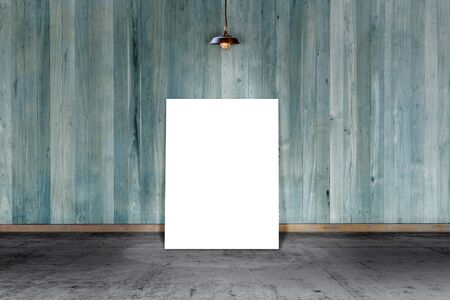 Poster standing on laminate flooring with lamp and wooden wall. write text on paper for advertise or public relationsの写真素材