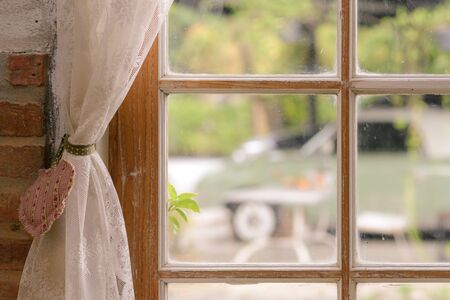 Close up of transparent white lace tulle on the window. Curtain and window interior decoration in vintage styleの写真素材
