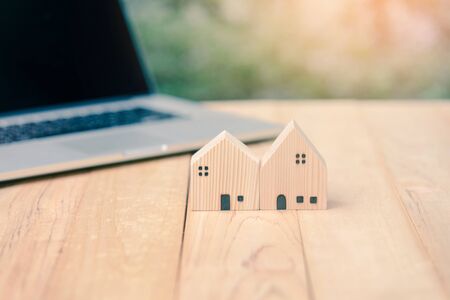 House model with computer laptop on wooden table. loan real estate or property mortgage investment conceptの写真素材