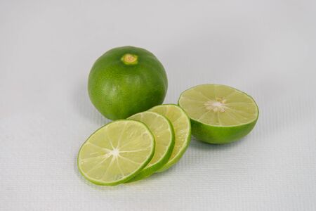Fresh ripe green limes with sliced on white canvas background
