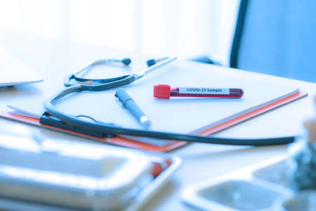 Blood test samples of Infected coronavirus or covid-19 in tube with stethoscope on table doctorの写真素材