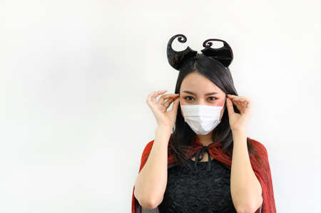 Portrait of beautiful young asian woman wearing red dress and black shawl and protection face mask...