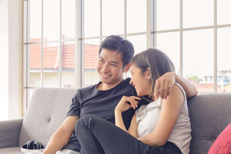 Young asian couple wear casual clothing relaxing on cozy couch in living room at home. Love,...