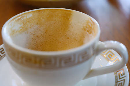 Close up ofÂ white foam in empty hot coffee cup after drink on wood table in cafeの写真素材