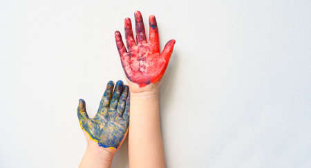 Colourful painted two child hands up isolated on white background. Creative, funny, artistic and...