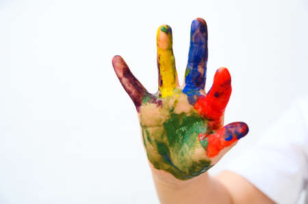 Colourful painted child hand up isolated on white background. Creative, funny, artistic and happyの写真素材
