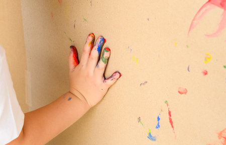 Childs hand and memorable handprint in brown paper. Creative, funny, artistic and happyの写真素材