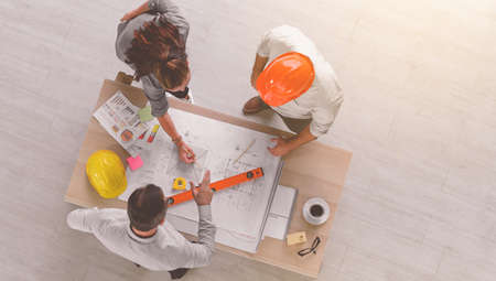 Top view of engineers team meeting for architectural project. architects discussing blueprint with construction manager in office worker conference site. Construction Conceptの写真素材