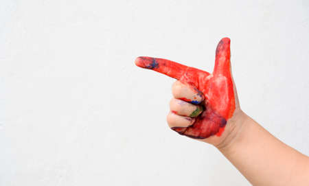 Colourful painted child showing thumb up isolated on white background. Close up copy spaceの写真素材