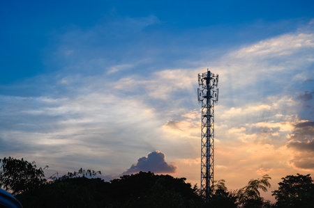 Silhouette of Tower antenna transmission. Repeater of communication and telecommunication with beautiful cloudy sky at sunset on background with copy spaceの写真素材