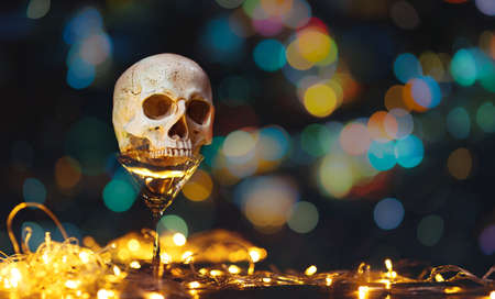 Human skull on empty drink glass and LED lights decoration with free copy space for text. decor for party - Halloween Backgroundの写真素材
