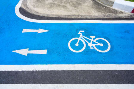 Blue bicycle lane on road with white bicycle icon and arrow. Empty Bicycle way for bikeの写真素材