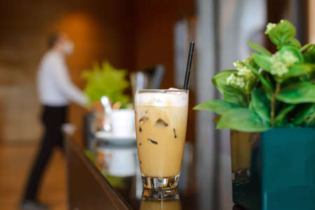 White cup of ice coffee waiting for customer on counter bar in modern cafe coffee shop. Coffee Break