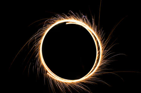 circle drawing light fireworks. Burning flare or flame with bright sparks on background with copy space. long exposure light paintingの写真素材