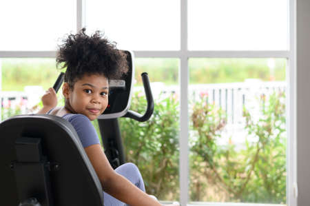 Portrait of happy African American girl in a gym. Sport, healthy lifestyle, active childhood concept. Look at cameraの写真素材
