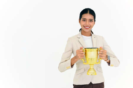 Portrait of Winning businesswoman celebrating with trophy award for success in business isolated on...