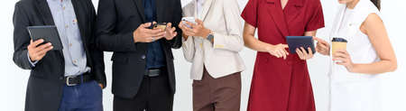 Banner cover design. Close up a group of business people using gadgets or smartphones while standing in a row. isolated on white backgroundの写真素材