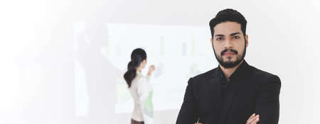 Confident bearded businessman smiling while standing and arms crossed, Businesswoman gives...