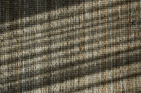 Top view of brown knitted doormat with sunlight and shadow. fabric mat texture for backgroundの写真素材
