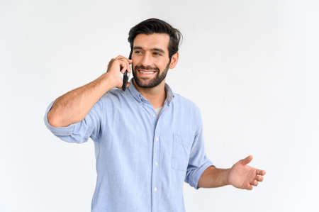 Portrait of smiling macho beard guy in blue t-shirt using smartphone standing over white background