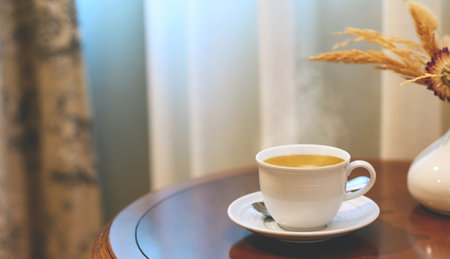 Hot Coffee in white cup on wooden table in kitchen room at comfort homeの写真素材