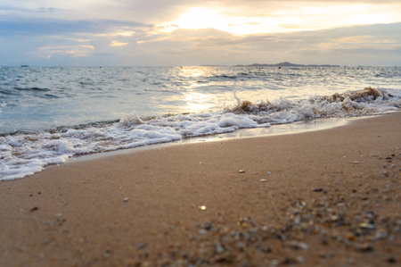 Seawater soft wave crashing on sandy beach seaside in summer on sunset time. summer vacation activity background concept.の写真素材