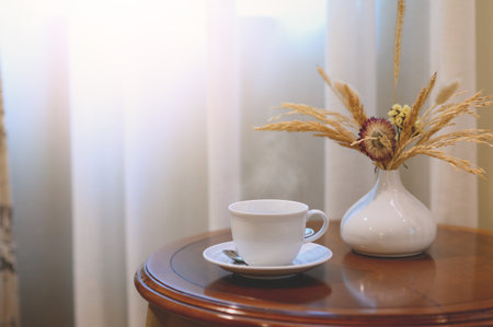 Hot Coffee in white cup on wooden table in kitchen room at comfort homeの写真素材
