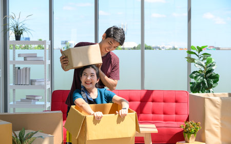 Young Asian couple move into new apartment on Moving Day, celebrating moving to new home conceptの写真素材