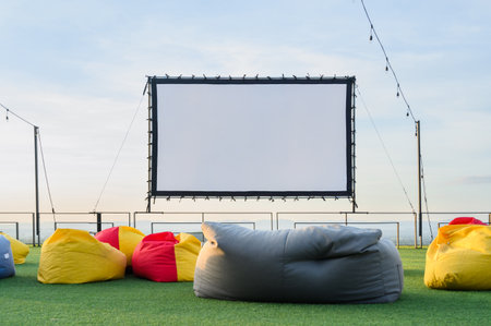 open air cinema with colorful bean bag. empty white screen, free space for text or montageの写真素材