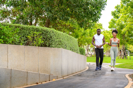 Young African American couple in sportswear running in public park. Jogging healthy conceptの写真素材