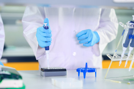 Male scientist working at the laboratory. Cloud up medical hand using micro pipette for test...