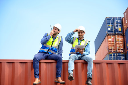 container operators wearing helmets and safety, vests control via walkie-talkie workers in container...