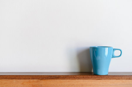 Blue coffee mug on wood table and white background with copy space. Selective focus on Coffee cupの写真素材