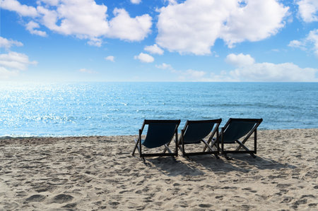 Relax time on the beach. beach chaise set up for travelers on the beach in Thailand with blue sky on...