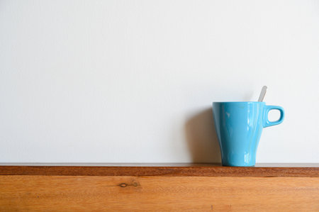 Blue coffee mug on wood table and white background with copy space. Selective focus on Coffee cupの写真素材