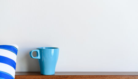 Blue coffee mug on wood table and white background with copy space. Selective focus on Coffee cupの写真素材
