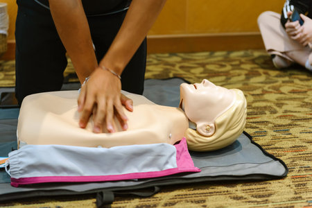 CPR First Aid Training with CPR dummy in the class. Demonstrating chest compressions conceptの写真素材