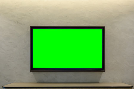 Mockup Television with green screen hanging on white wall. Green blank monitor mockup. TV 4K flat screenの写真素材